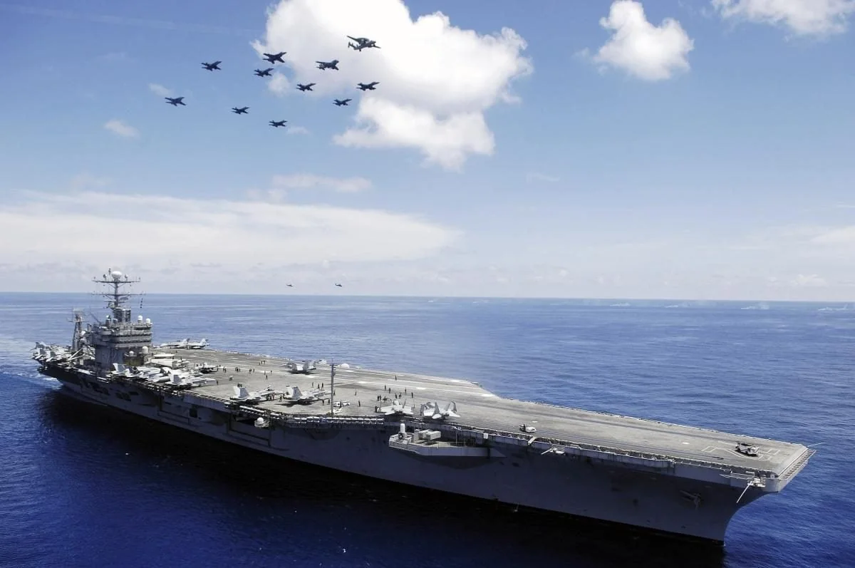 Авіаносець USS Abraham Lincoln з винищувачами у небі над океаном