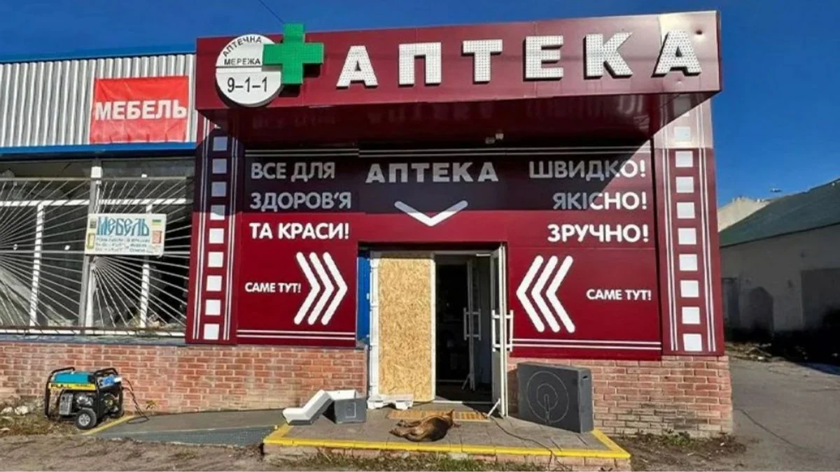 Пошкоджена аптека «9-1-1» з вивіскою «Без години без тривоги, але ми працюємо» на фронті