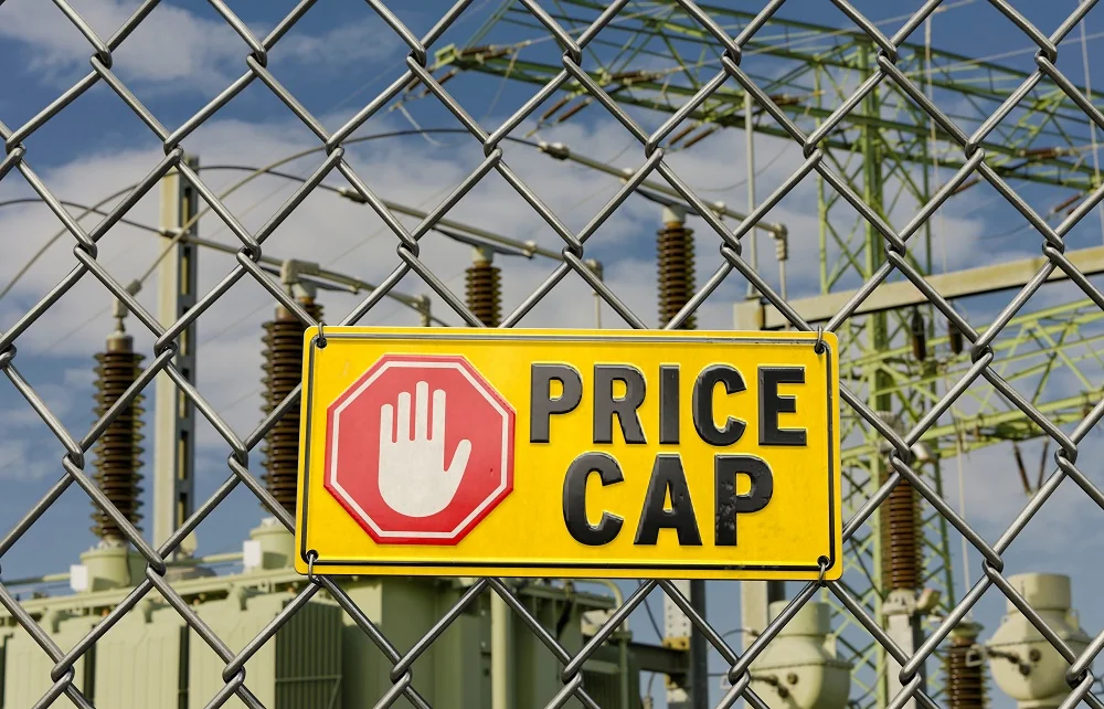 Жовтий знак PRICE CAP на огорожі електростанції символізує низькі прайс-кепи, що блокують імпорт.