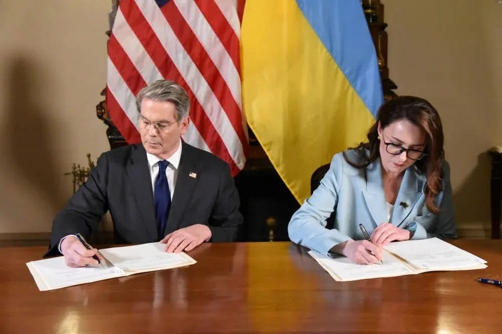 Американский и украинский дипломаты подписывают соглашение перед флагами США и Украины