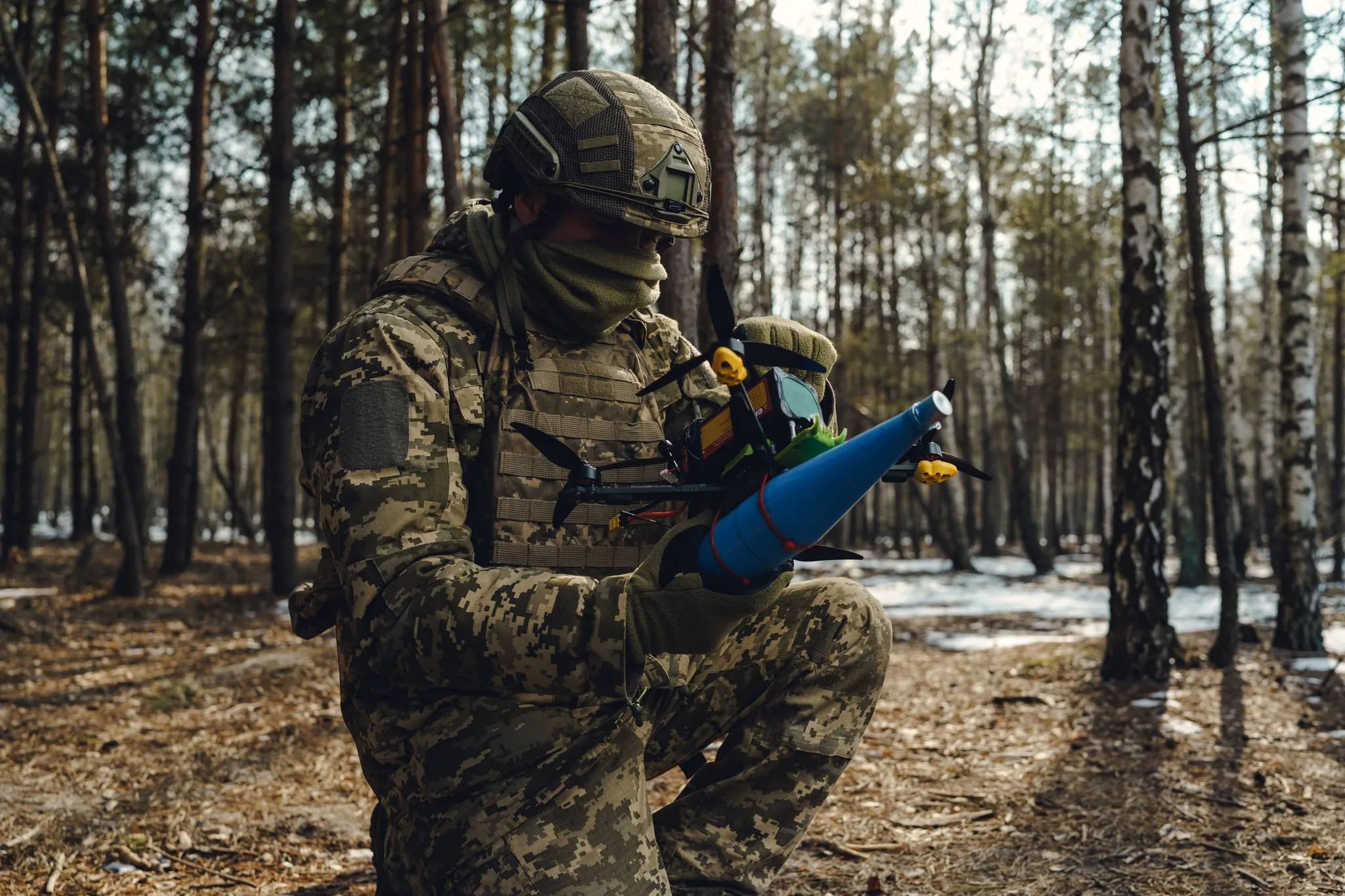Російський дронівник тримає FPV-дрон на лісному полігоні під час підготовки