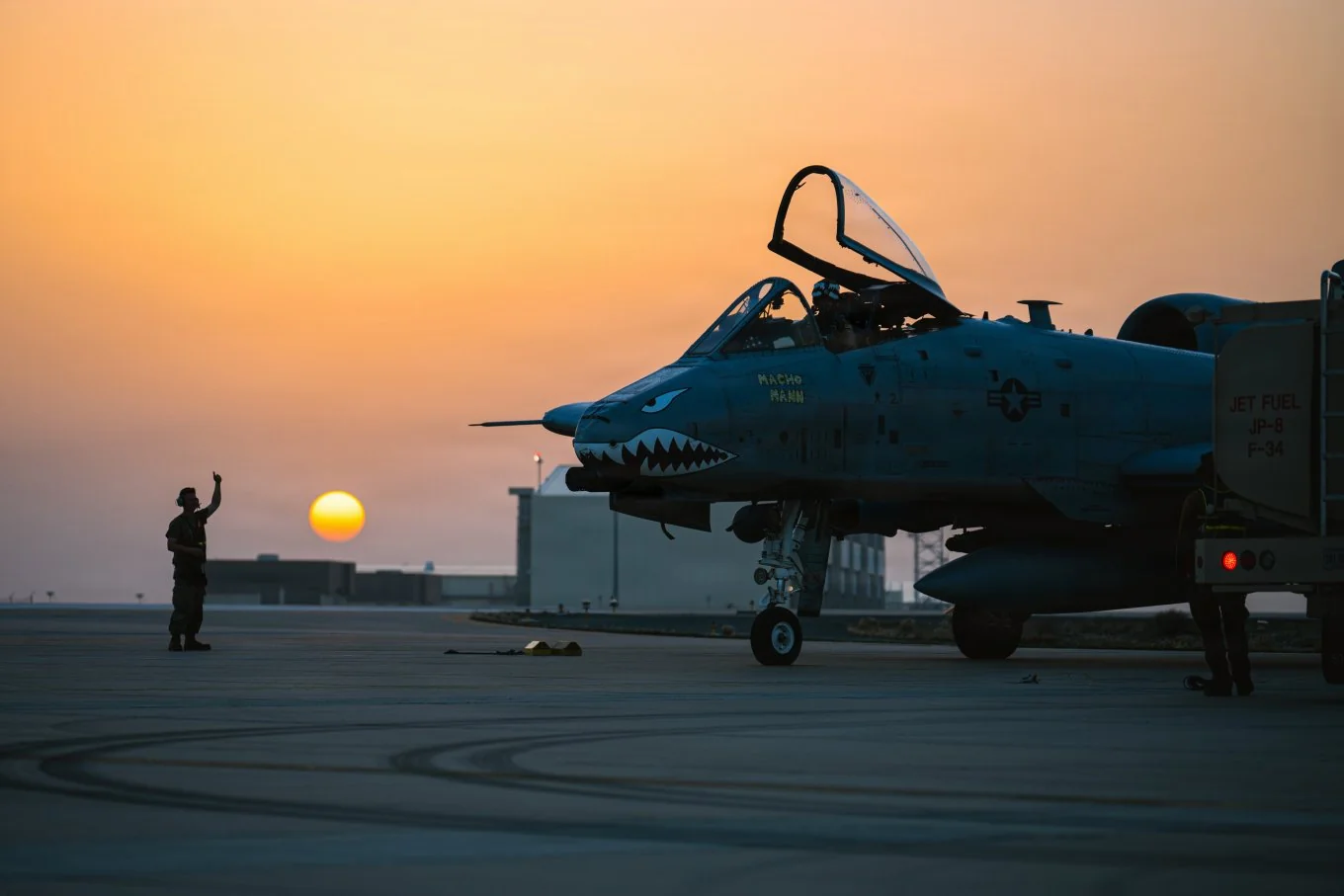 Военный салютует штурмовику A-10 Thunderbolt II на закате солнца на базе Дэвис-Монтан