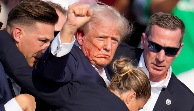 Дональд Трамп с раненым лицом поднимает кулак после стрельбы на митинге