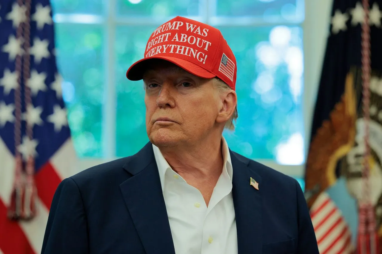 Дональд Трамп в кепке «TRUMP WAS RIGHT ABOUT EVERYTHING» на фоне флагов США