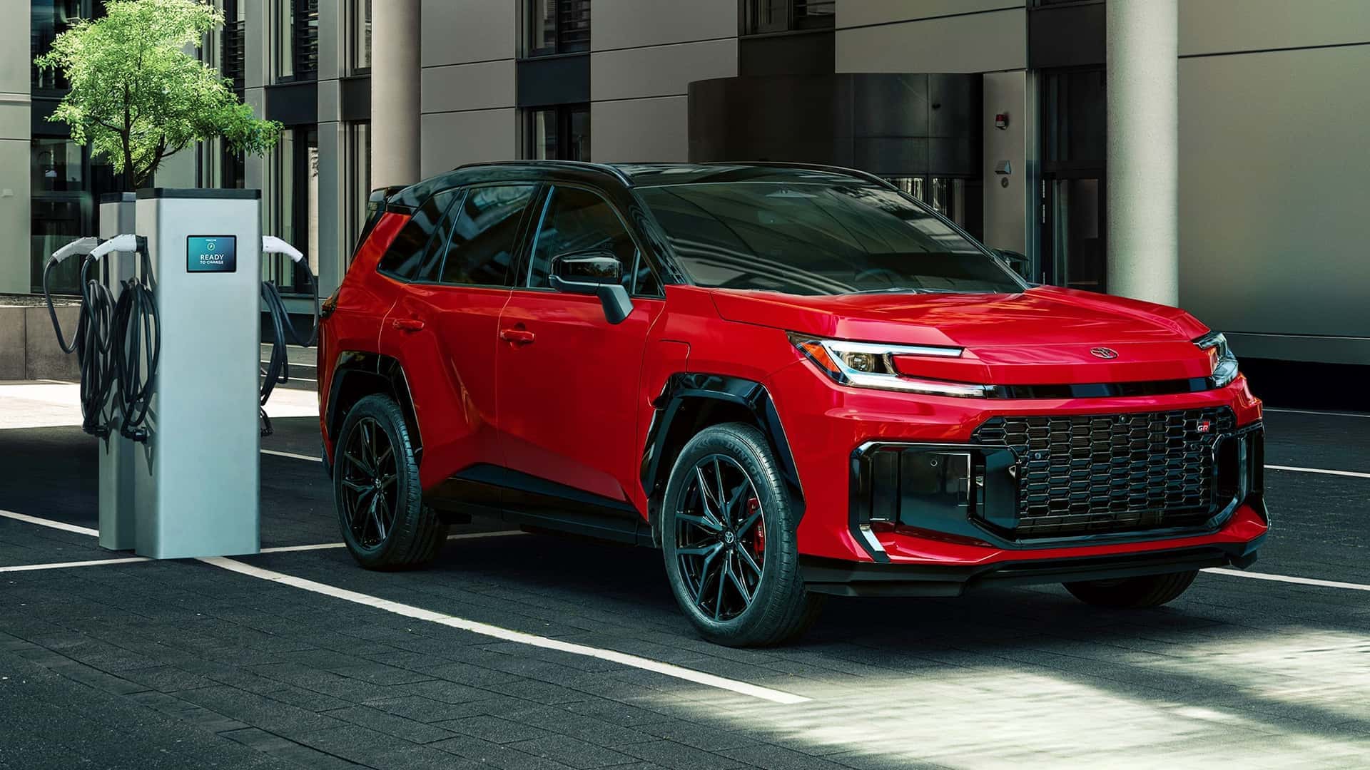 Червоний гібридний Toyota RAV4 заряджається біля електростанції в Україні