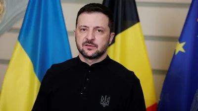 Владимир Зеленский перед флагами Украины и ЕС относительно оккупации россиянами