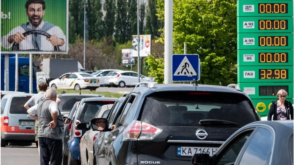 Черга авто на АЗС біля білборда Зеленського з цінами бензину A95 та дизелю