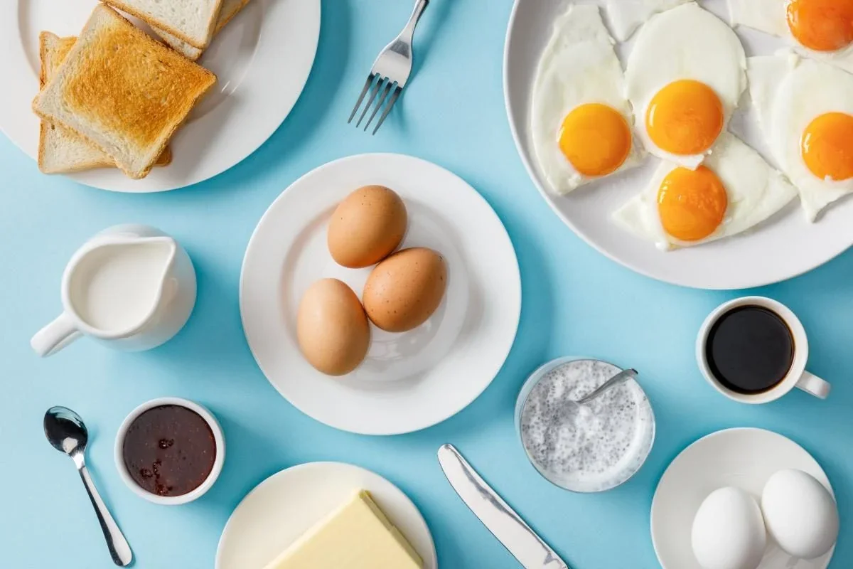 Яйця на сніданок з тостами, маслом, кавою та іншими продуктами для ситості