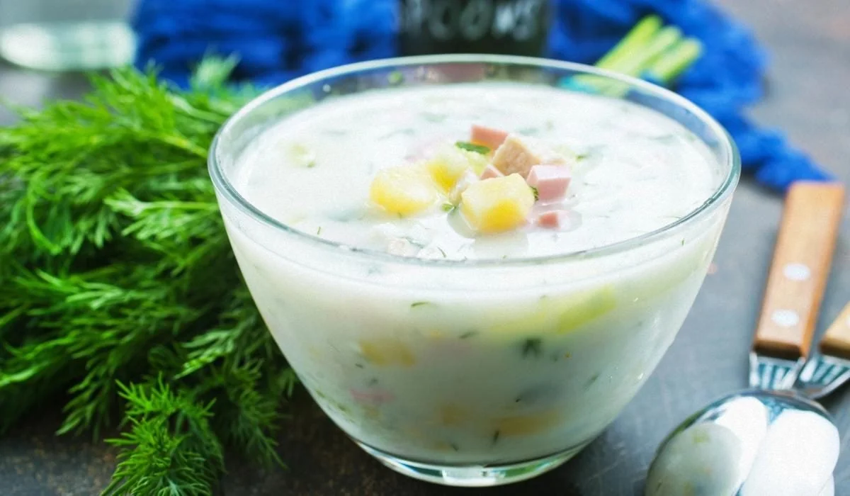 Порція ідеальної окрошки з бульйоном, картоплею, шинкою та зеленню