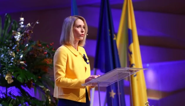 Кая Каллас за трибуною з прапорами ЄС та України під час заяви про переговори