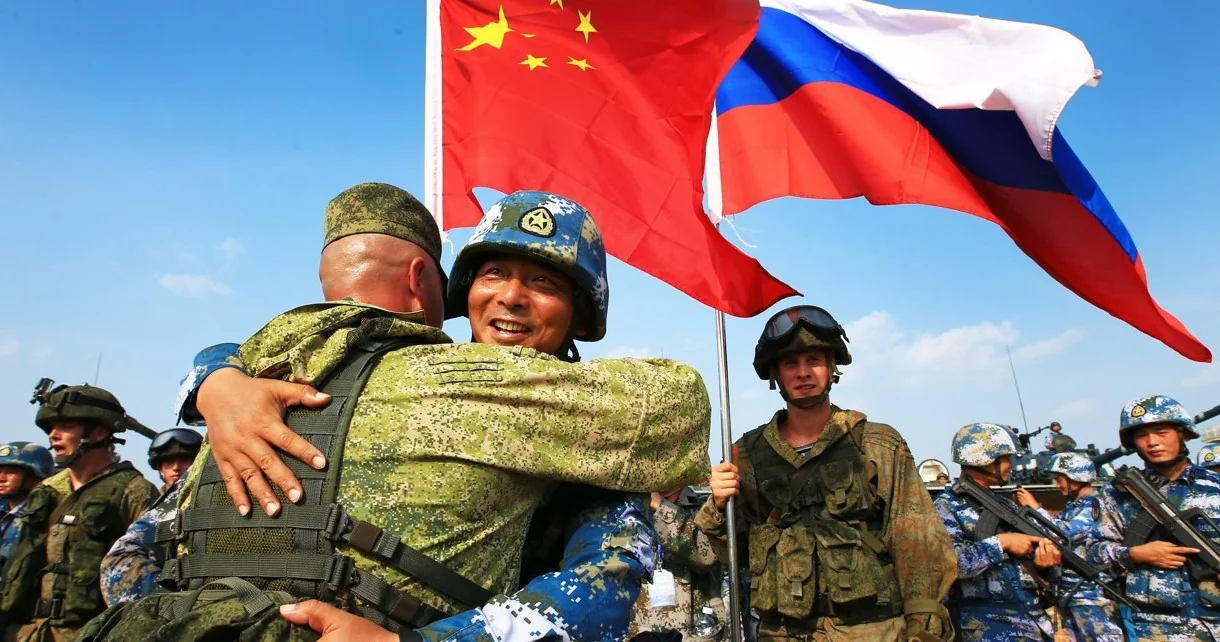 Російські та китайські військові обіймаються під час таємної підготовки в Китаї