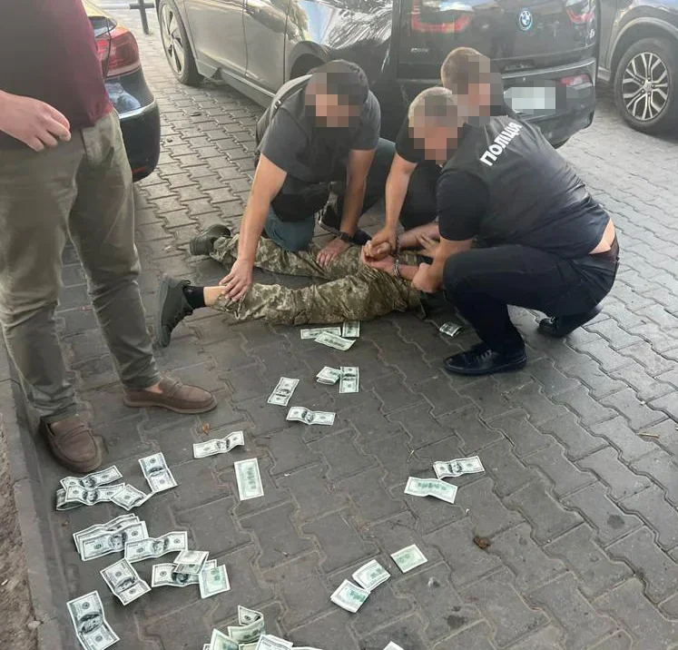 Поліцейські затримують підозрюваного за хабарі серед розкиданих грошей