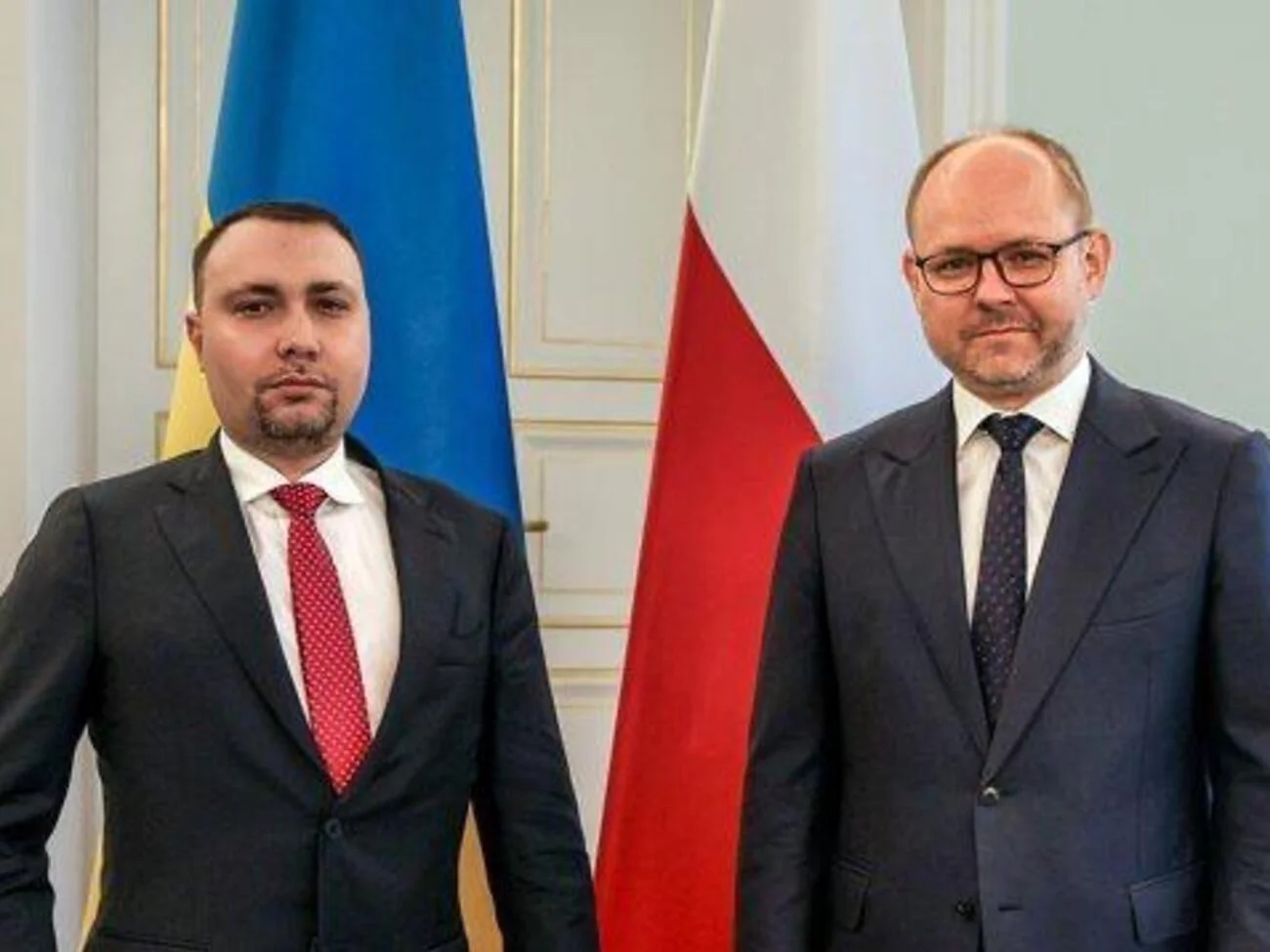 Посадовці України та Польщі на тлі національних прапорів під час дипломатичної зустрічі