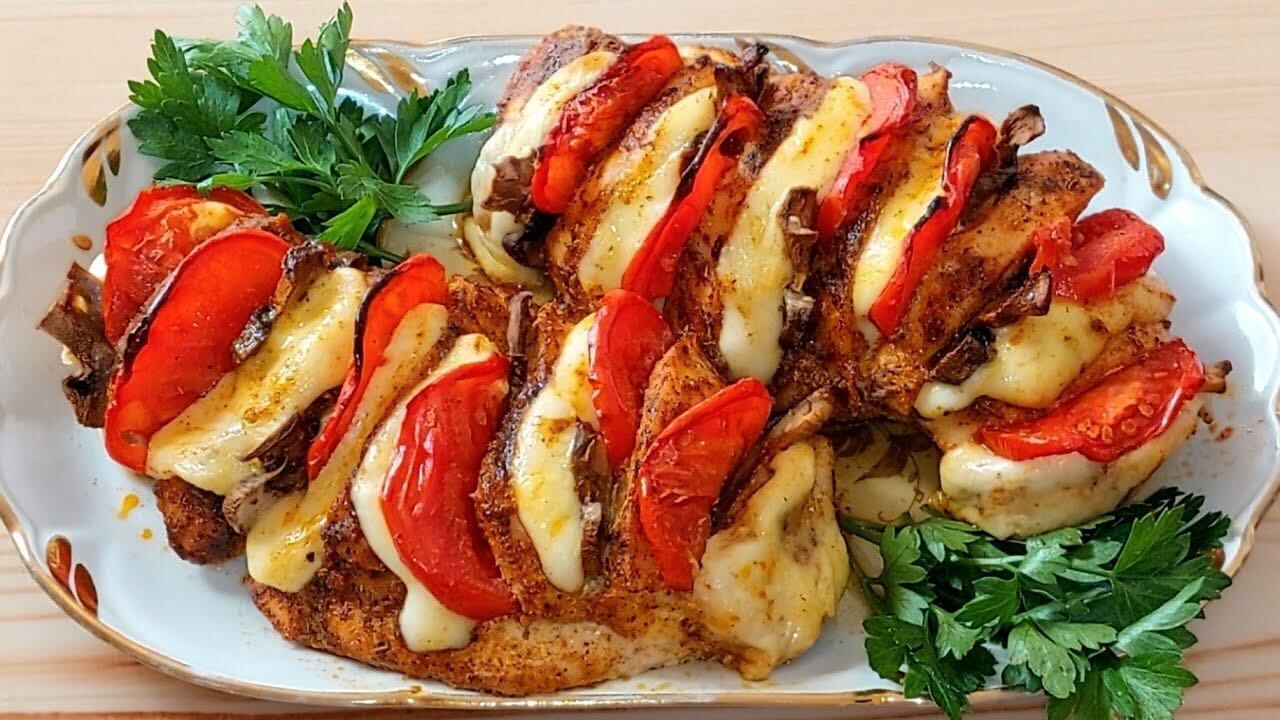 Куриное филе в духовке с сыром, перцем и зеленью на тарелке