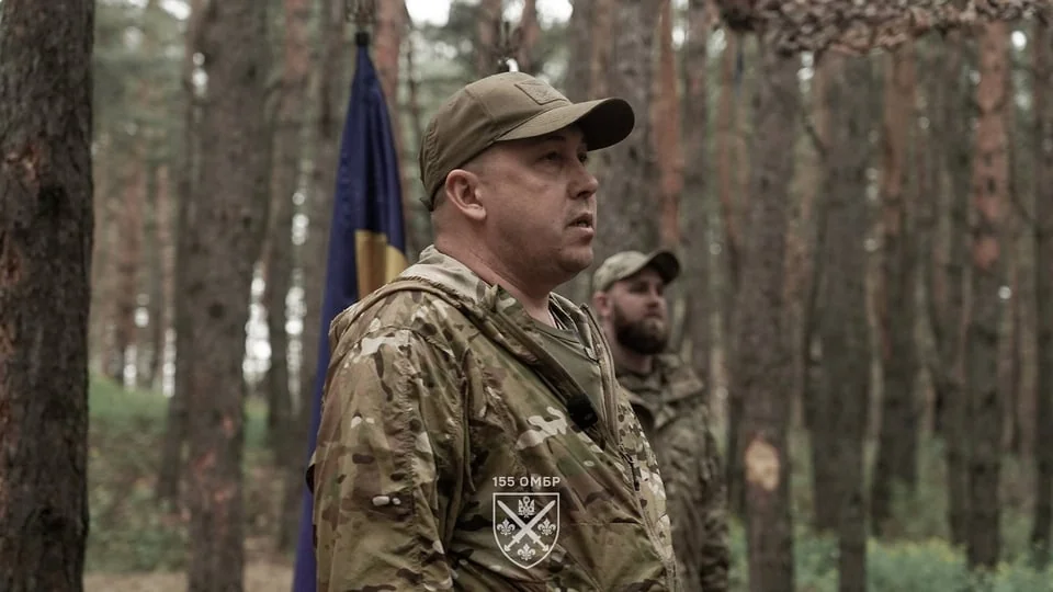 Командир 155-ї ОМБр Станіслав Лучанов у камуфляжі на фоні прапора України