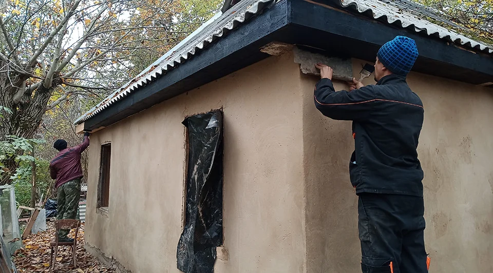 Робітники відновлюють стіни сторічної хати-мазанки біля Дністра