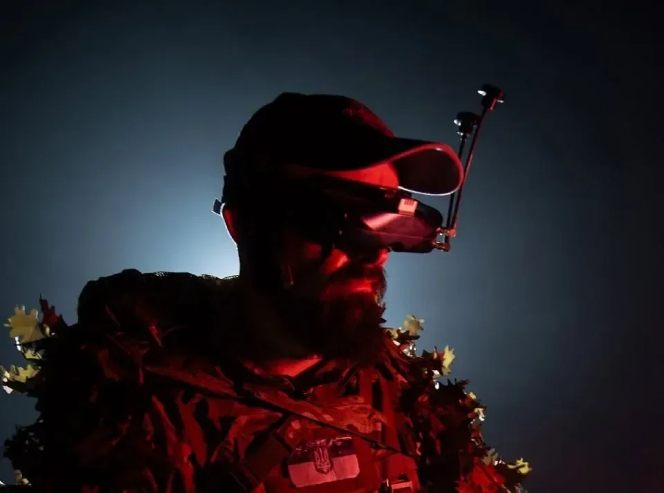 Оператор FPV-дрона 29-ї бригади в камуфляжі з окулярами під червоним світлом