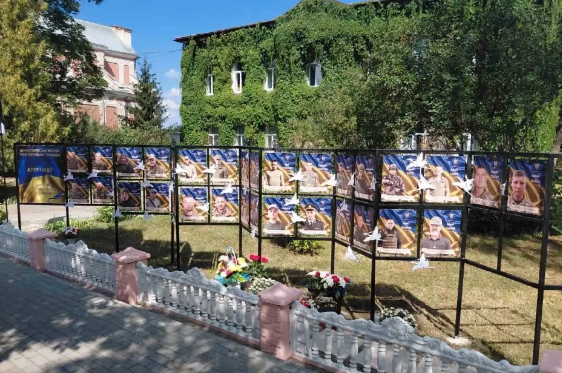 Портрети захисників на стендах Алеї Надії в Монастириськах серед квітів і голубів