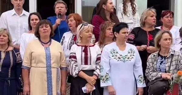 Група вчителів у вишиванках стоїть біля школи на святі Першого вересня